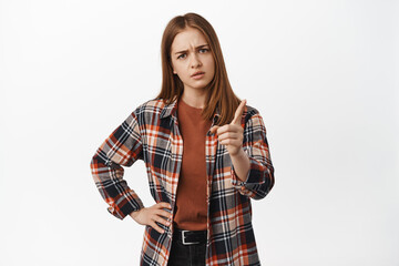 You better not. Serious young woman shaking finger and furrow eyebrows displeased, scolding bad...