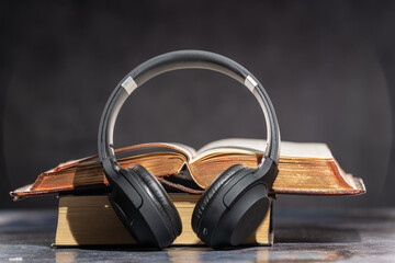 Headphones lying next to old books. Audiobook Concept