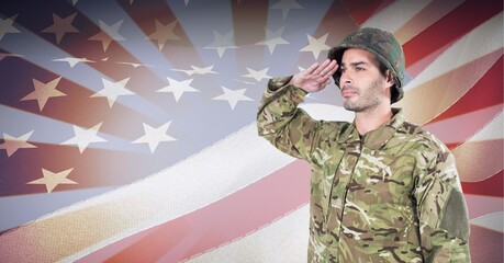 Composition of male soldier saluting over american flag