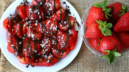 Strawberries with chocolate on a plate. Fresh strawberries in a bowl. Healthy summer dessert with strawberries.