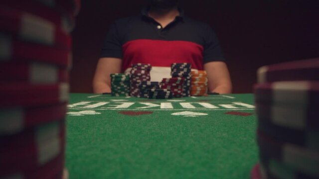 Male player betting all chips in while playing in casino, close up