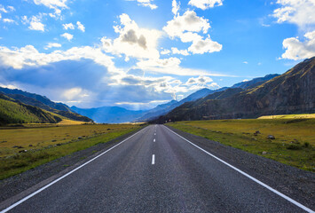 Empty road goes to horizon on mountains backdrop. Altay mountains, Siberia, Russia.