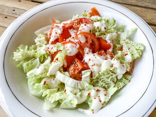 soft focus image of vegetable salad with dressing. sesame seeds and chilli flakes as topping.