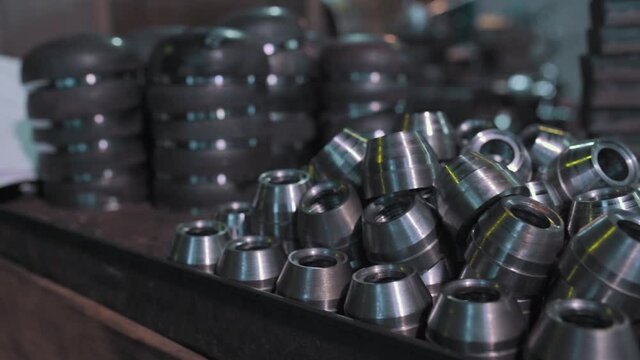 Close up of metal parts of a pipe fitting plant. Video. Metal new shiny bushings at the metallurgical factory.