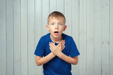 What wonderful news. Surprised preteen boy in blue t shirt express overjoy and surprised, hear...