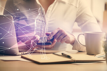 Double exposure of creative hologram and woman holding and using a mobile device. Start up concept.