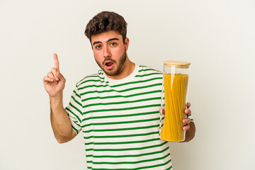 Young caucasian woman holding pasta jar isolated on white background having some great idea, concept of creativity.