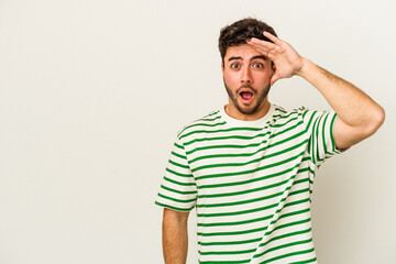 Young caucasian man isolated on white background shouts loud, keeps eyes opened and hands tense.