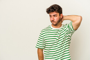 Obraz premium Young caucasian man isolated on white background touching back of head, thinking and making a choice.