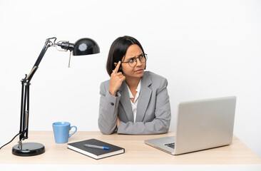 Young business mixed race woman working at office having doubts and thinking