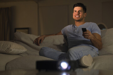 Man watching movie on sofa at night, space for text