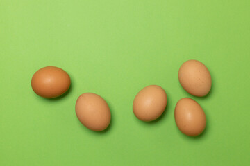 Brown chicken eggs on a green background. Minimal food concept idea. Happy Easter. Patterns.