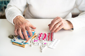 An older retired woman is counting money and saving it for medicines, medical treatment and insurance. Taking care of your health and wise investment.
