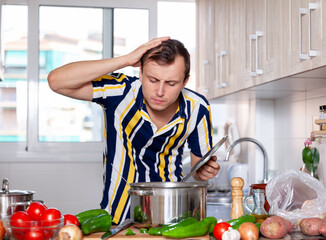 Ordinary man does not know how to cook soup in the kitchen