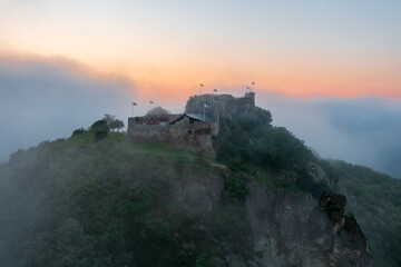 Obraz premium Aerial view abour castle of Sirok with misty matra mountains at the background. Spring sunrise landscape.