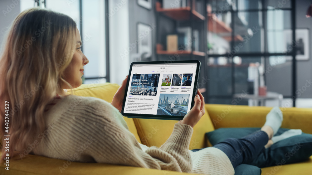 Poster beautiful authentic female using tablet computer for reading latest news and articles about technolo