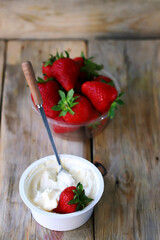 Cream cheese in a bowl and fresh strawberries. Processed Camembert cheese with strawberries.