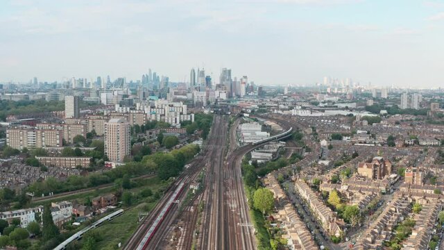 dolly forward drone shot of busy British rail train tracks towards London city centre