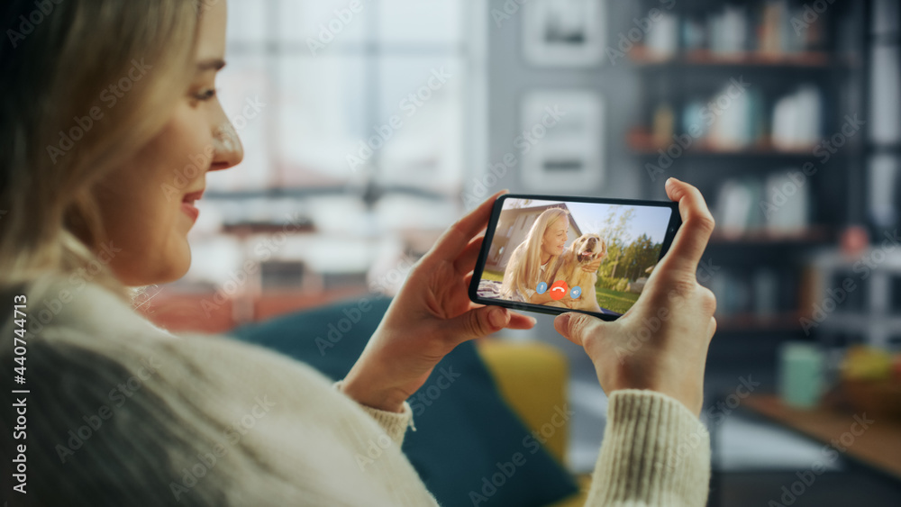 Poster close up of a female chatting in a video call with her beautiful friend playing with a dog on smartp