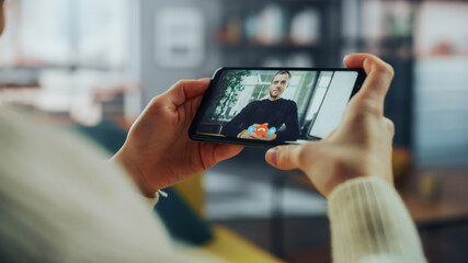 Close Up of a Female Chatting in a Video Call with Her Handsome Caucasian Male Friend on Smartphone from Living Room. Freelancer Making a Call from Home with Manager at the Office Over the Internet.