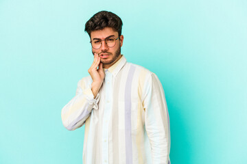 Young caucasian man isolated on blue background having a strong teeth pain, molar ache.