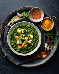 Palak Paneer on dark background, top view