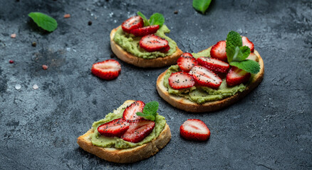 Toast with mashed avocado, strawberries and chia seeds, Delicious breakfast or snack, Keto diet toast. Vegan healthy food concept. Long banner format. top view