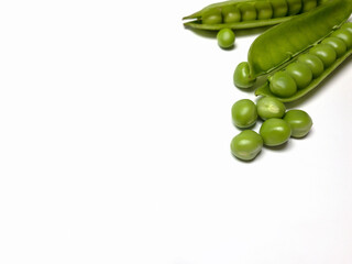 green peas in a pod in a corner on white background
