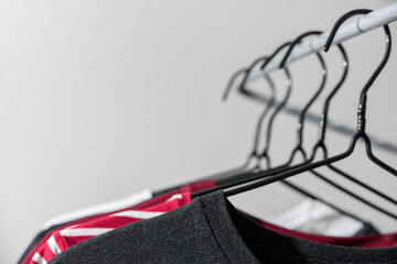 Obraz premium Black and red clothes on hangers on rail