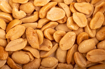 Roasted salted peanuts, surface texture. Close-up, selective focus.