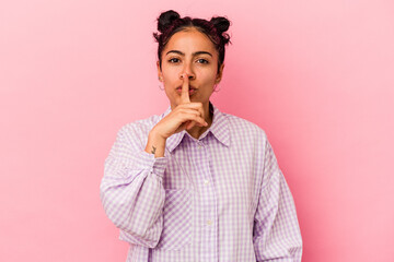 Young latin woman isolated on pink background keeping a secret or asking for silence.