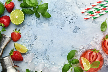 Two glasses of punch and fresh ingredients for making lemonade, infused detox water or cocktail. Strawberries, lime, mint, basil, ice cubes and shaker on grey stone or concrete background. Top view.