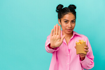 Young latin woman holding chips isolated on blue background standing with outstretched hand showing...