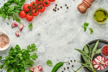 Fototapeta na wymiar Food cooking background. Fresh saffron, garlic, cilantro, basil, cherry tomatoes, peppers and olive oil, spices herbs and vegetables at light grey slate table. Food ingredients top view.