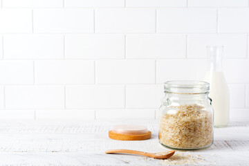 Fototapeta na wymiar Raw White rice variety Arborio for Italian risotto dishes in glass jar on white concrete or stone background. Selective focus. Copy space