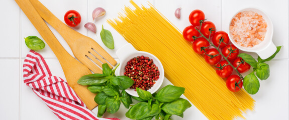 Spaghetti, fresh tomato, herbs and spices. Composition of healthy food ingredients isolated on white background, top view. Mock up.