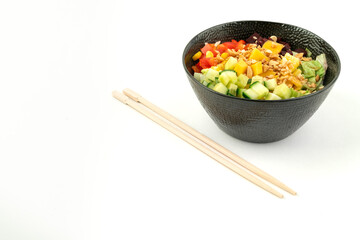 Vegetarian poke bowl in design black bowl with chopsticks below, isolated on white background....