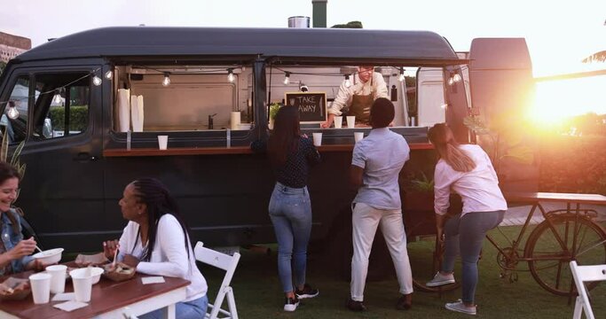 Multiracial people ordering gourmet food in front of food truck outdoor - Multigeneratiol friends having fun eating dinner outside at summer time