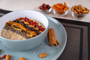 Breakfast in the kitchen, oatmeal with dried fruits and seeds and coffee. Healthy food concept