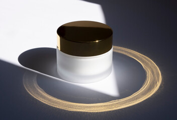 a white glass jar for moisturizing cream with a gold lid on a palm leaf background. Mockup for branding product packaging.