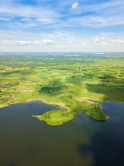 Beautiful landscape on the Braslav Lakes from a drone on a sunny day with a sky with clouds, Belarus. Vertical photo. Peninsula in the form of a boot
