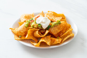 nachos tortilla chips with jalapeno, guacamole, tomatoes salsa and dip