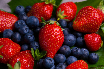 fresh strawberry and blueberry with leaves. Sweet ripe berries. Berry background. Healthy vegan food