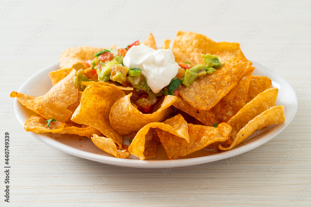 Sticker nachos tortilla chips with jalapeno, guacamole, tomatoes salsa and dip