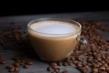 coffee latte on dark background with coffee beans. coffee mug with milk and foam