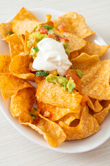 nachos tortilla chips with jalapeno, guacamole, tomatoes salsa and dip