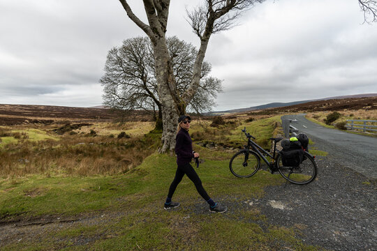 Closeup shot of a Caucasian female with a bicycle near Blessington lake in Ireland