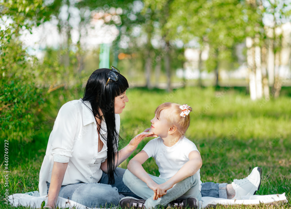 Wall mural happy little girl and her mother having fun outdoors on the green grass in sunny summer day