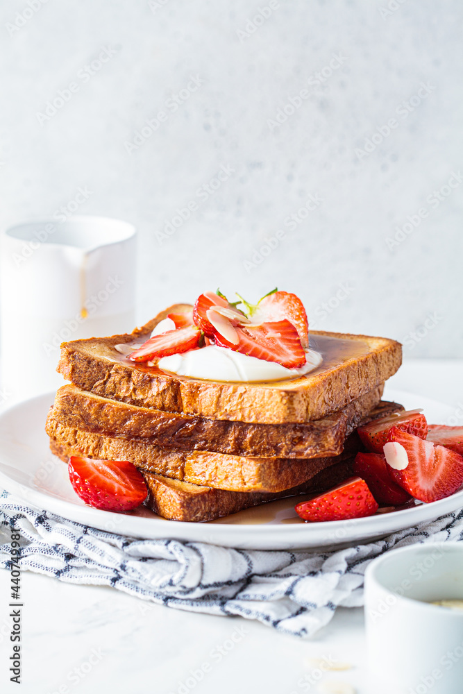 Poster A stack of French toast with strawberries, yogurt and maple syrup. Breakfast concept.