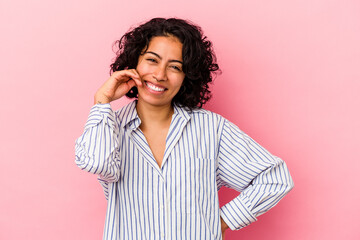 Young curly latin woman isolated on pink background laughing about something, covering mouth with hands.